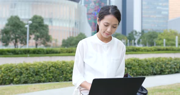 Asian woman use of laptop computer in city