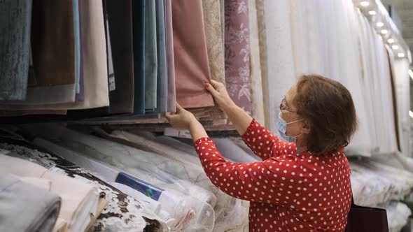 Elderly Woman Choosing New Curtains in a Store