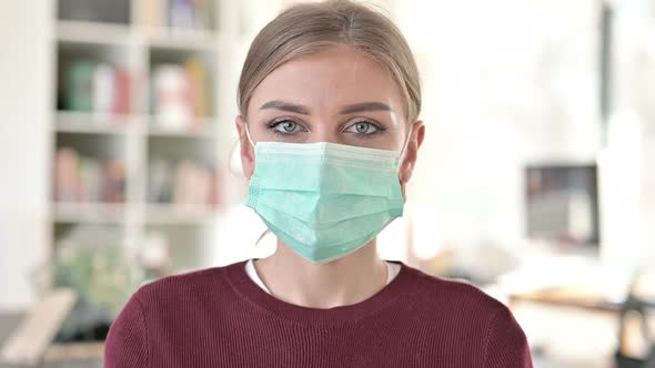 Portrait of Cautious Young Woman with Face Mask 