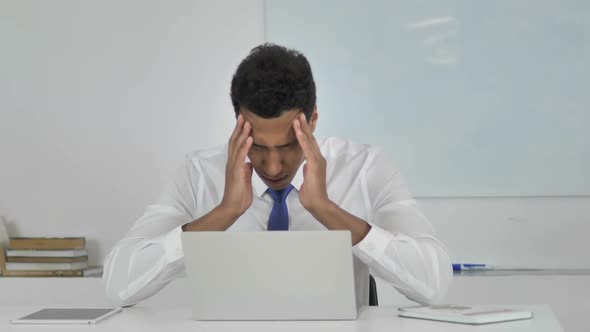 Stressed AfroAmerican Businessman with Headache Working on Laptop