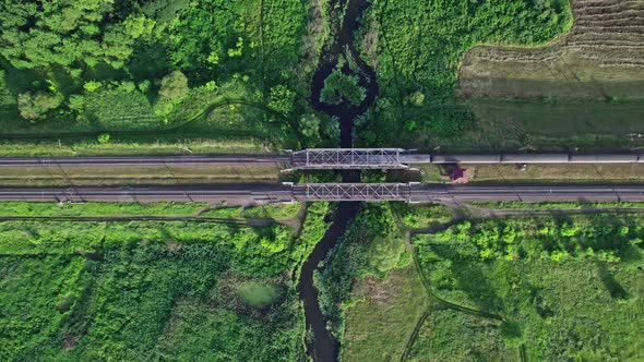 Metal Structure Railway Bridge Over a Small River and the Trees of a Forest