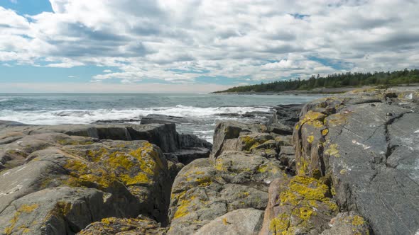 Beautiful tidal waves crashing on stone rocky coastline, time lapse