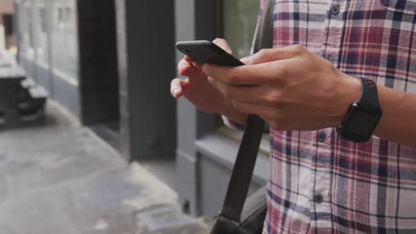 Caucasian man using his phone on street