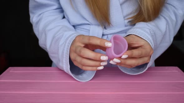 Girl Hold Menstrual Latex Silicone Cups in Hands Compresses Folds