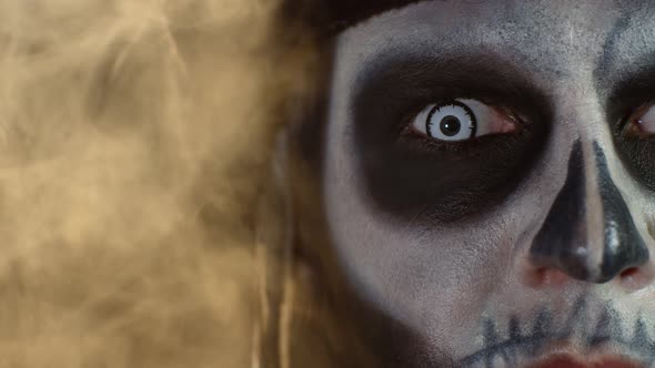 Close-up Macro Shot of Creepy, Scary Man Face with Skeleton Makeup Opening Eyes with White Pupil