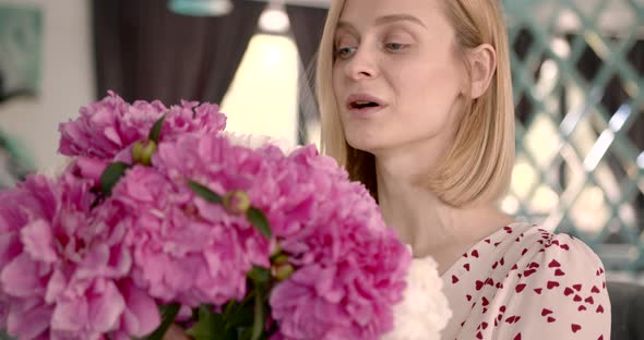 Pretty Blonde Woman Holding a Bunch of Peonies