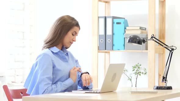 Young Woman Using Smartwatch, Sitting in Office