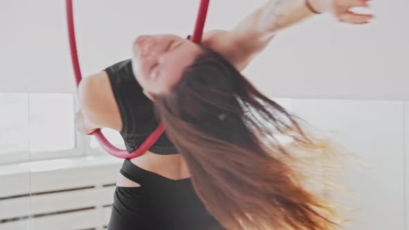 Young Gymnastic Woman with a Tattoo Training with the Acrobatic Ring in the White Studio