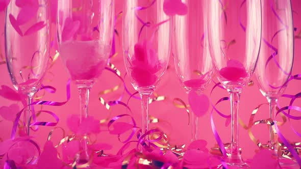 Sparkling wine is poured into glasses against the background of falling confetti 