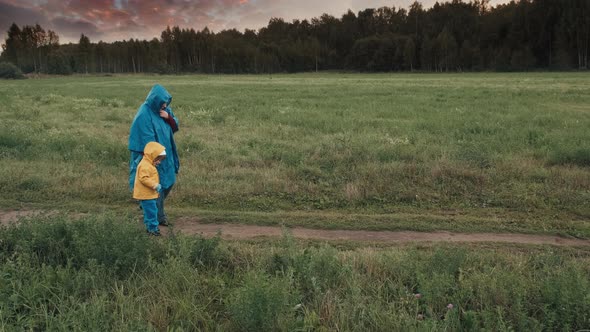 Woman Walks in the Park in the Evening with a Small Child