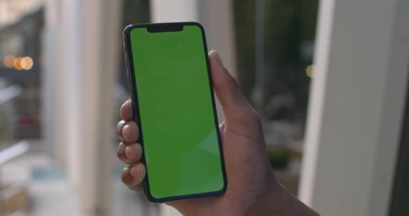 Close Up View of Male Hand Touching Modern Mobile Phone with Mock Up Screen. Afro American Man Using