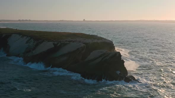 Aerial Footage of Foamy Ocean Waves with Mirrored Sunset