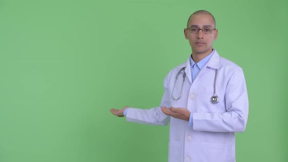 Stressed Bald Multi Ethnic Man Doctor Showing To Back