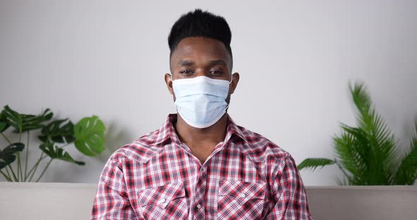 Young african man wearing face mask talking to camera