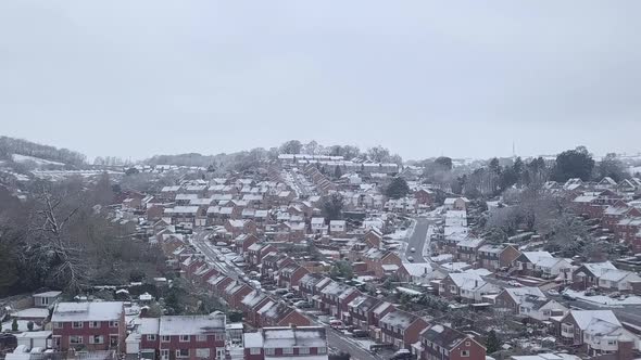 Ascending dolly forward drone shot of snowy Exeter subburbs CROP