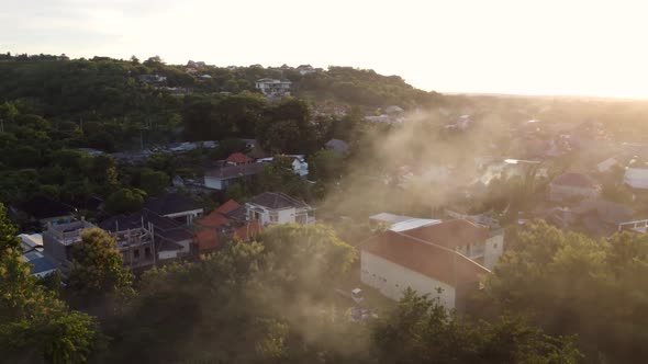 Drone flying in the smoke over the city sunset