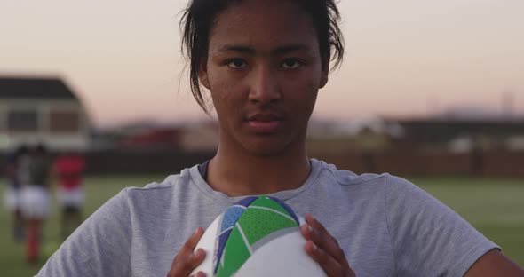 Portrait of young adult female rugby player on a rugby pitch