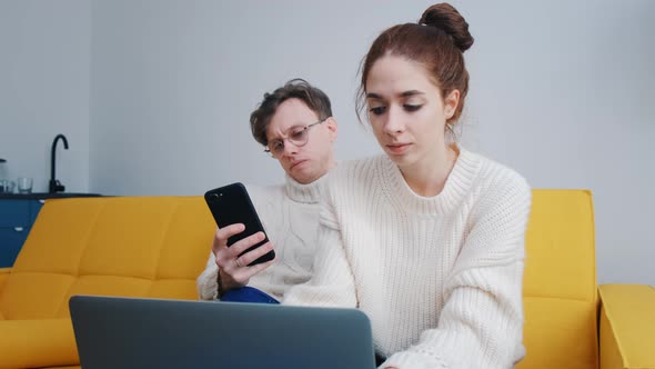 a Smiling Young Couple Using Laptop at Home Indoor