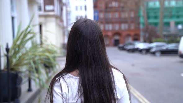 Following a woman, she turns, hair flips, Soho, London, close up slow motion