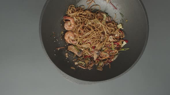 Professional Cook Frying Vegetables with Noodles