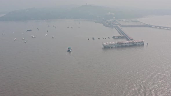 Establishing aerial drone shot towards Mandwa Jetty India on a hazy day