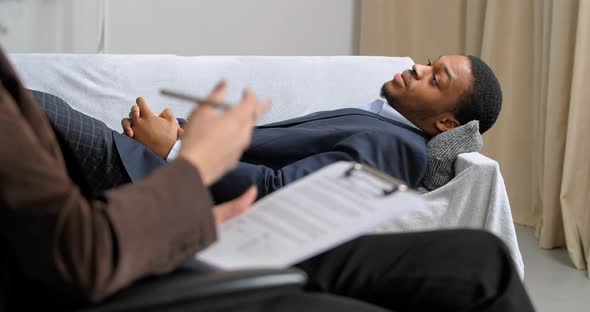 Afro American Business Man Lies on Couch in Office of Psychologist Consults with Psychiatrist Going