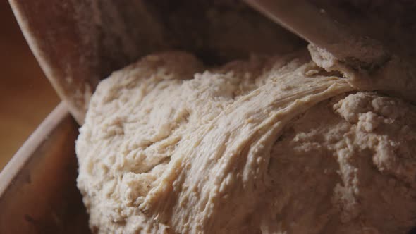 BAKING - Wooden spooning sourdough bread dough, slow motion tilt down