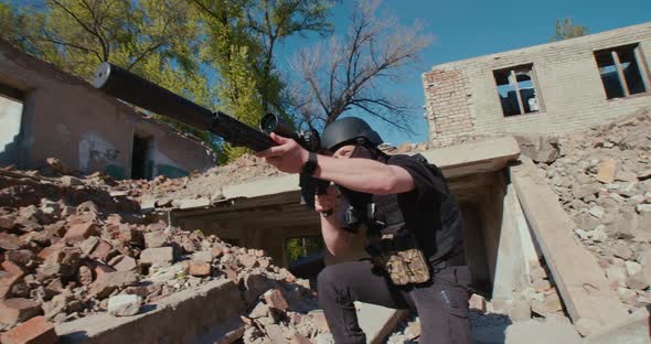 A Soldier with a Weapon Gets Out of the Destroyed House and Shoots