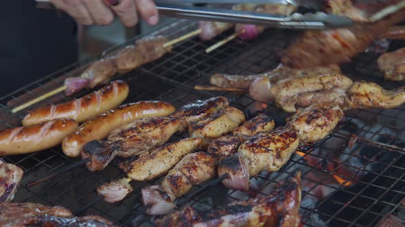 An aerial view of a unrecognizable man hands smoked pork meat on outdoor barbecue. Preparing dinner