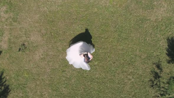 Top down aerial view of wedding couple spinning in a park 27