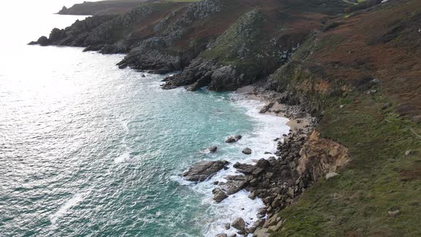 Rocky coast of Minack in Cornwall, England. Aerial forward tilt up reveal