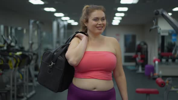 Portrait of Smiling Confident Plussize Woman Walking in Gym Looking Around Smiling