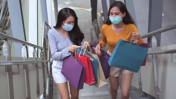 Asian woman wearing face mask. Happy woman with shopping bags