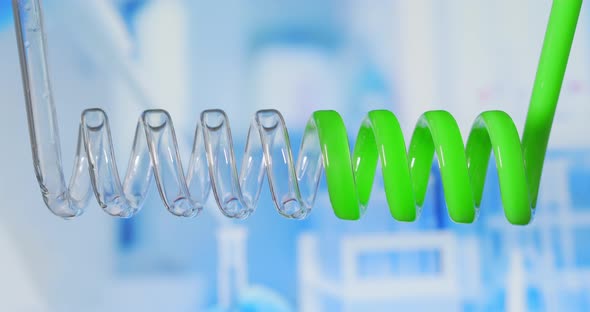 Close Up and Slow Motion of Green Colored Liquid Spiraling in Scientific Glass Condensers