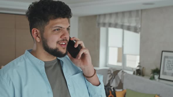 Young Man Chatting On Phone In Modern Living Room