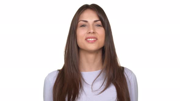 Attractive Young Caucasian Brunette Waving Her Head in Consent and Showing Ok Over White Background