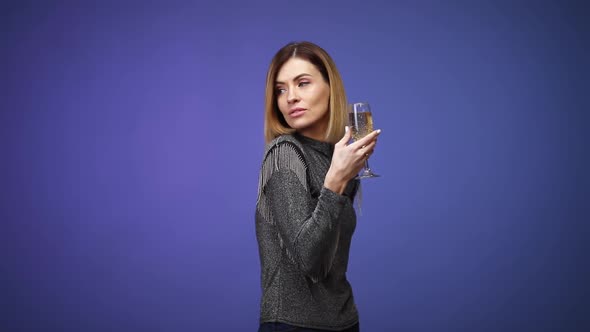 Woman in Silver Shirt Holding Glass of Champagne and Smiling