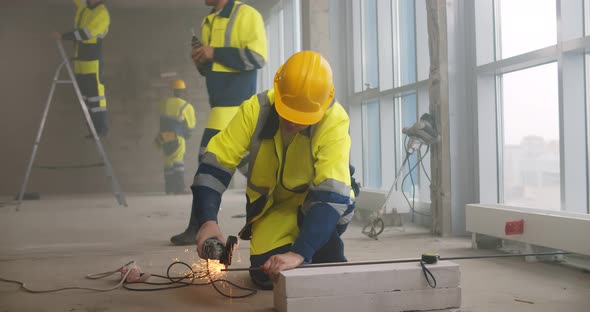 Builder Using Metal Grinder Cutting Steel Bar at Construction Site