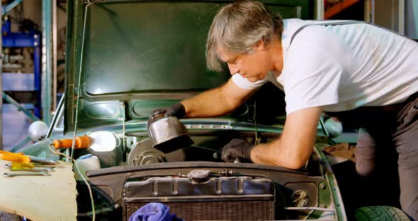 Male mechanic servicing a car