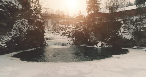 Winter Sun Resort with Mountain Waterfall Slow Motion Aerial