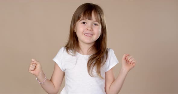 Cute Little Girl in White Tshirt Dancing, Smiling and Having Fun in Studio Session