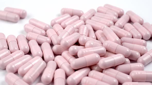 Close up of the rotation soft pink pills or capsules on white background