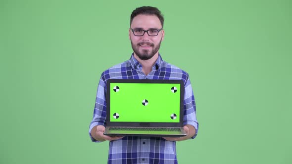 Happy Young Bearded Hipster Man Thinking While Showing Laptop