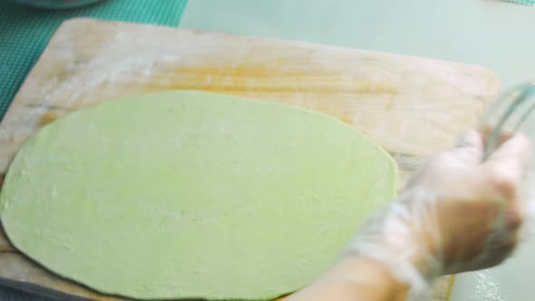 The Chef Spreads the Green Dough with a Rolling Pin