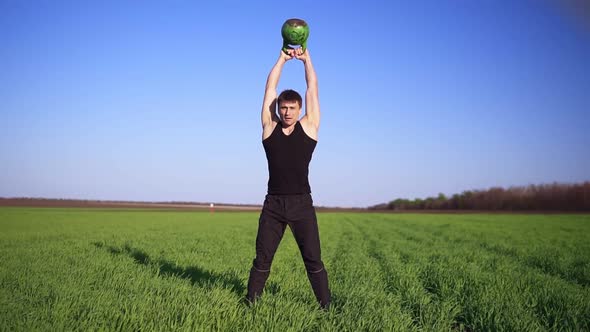 A Strong Man Demonstrates an Exercise with Weight