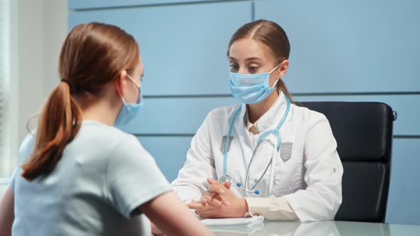Young woman general practitioner in blue disposable face mask