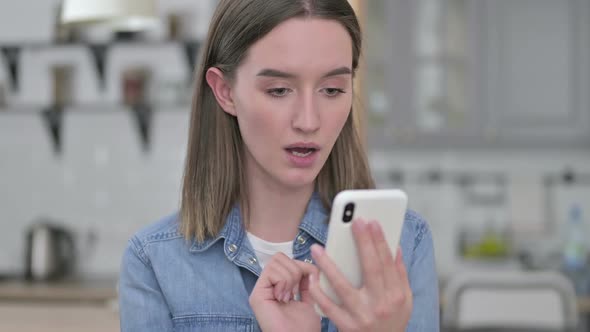 Portrait of Upset Young Woman Reacting to Loss on Smartphone