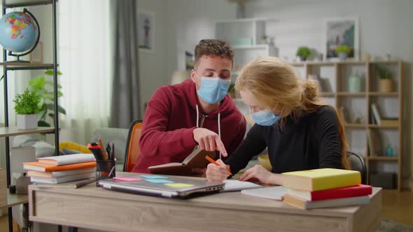 Young Tutor Man is Studying with a Young Woman at Her Home During Quarantine