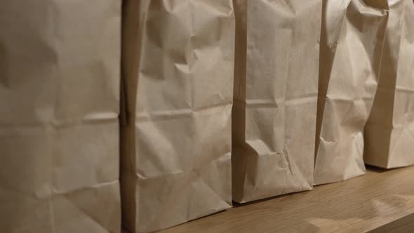 Paper Bags with Guest Orders on Wooden Table in Cafe