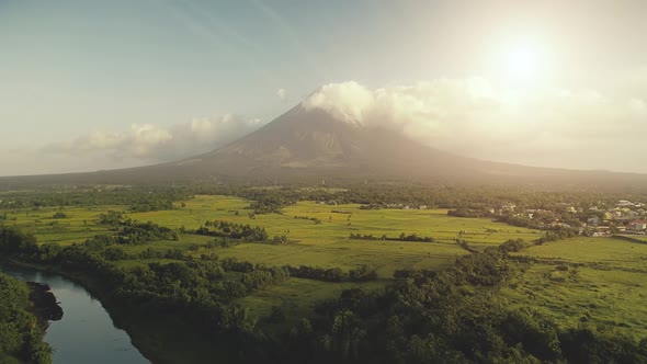 Sun Shine Over Mayon Volcano Erupts Aerial, River at Green Grass Hillside, Tropic Forest at Legazpi